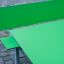 Green Table HPL with matching green bench setup on cobblestone paving.