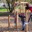 Children playing on Somersault Triple playground equipment in a park