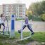 Two women exercising on an Air Walker outdoor fitness equipment in a park.