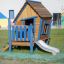 wooden playhouse with a slide