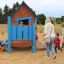 children playing in the wooden playhouse on the playground