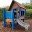 wooden themed playhouse with a slide