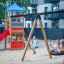 Children playing on Bird Nest Swing with Tower (BNS 90 cm) playhouse with slide in a playground.